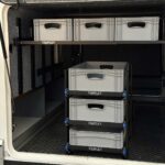 Starflex firkantet teleskoprør montert i modulskinner i bobilens lasterom med eurobokser stablet i flere nivåer for maksimal plassutnyttelse